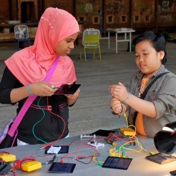 1 boy and 1 girl perform experiments using PV solar panels during a solar workshop